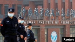 当世卫组织新冠病毒源头调查组视察武汉的中国科学院病毒研究所期间,中国保安人员在研究所外站岗。 (2021年2月3日)