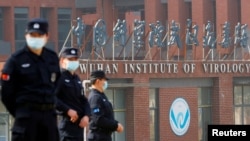 当世卫组织新冠病毒源头调查组视察武汉的中国科学院病毒研究所期间,中国保安人员在研究所外站岗。 (2021年2月3日)