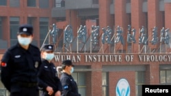当世卫组织新冠病毒源头调查组视察武汉的中国科学院病毒研究所期间,中国保安人员在研究所外站岗。 (2021年2月3日)