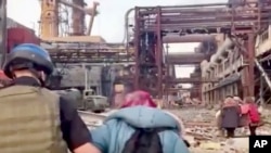 Фото: люди на території зруйнованого заводу "Азовсталь".