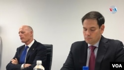 资料照:2019年11月12日,代表佛罗里达州的两位共和党籍联邦参议员鲁比奥(右)与斯科特(左)在该州的一个论坛上。
