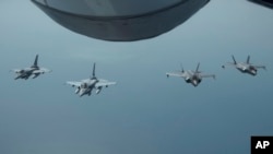 资料照片:美国空军发布的照片显示阿联酋空军沙漠猎鹰战机与美国F-35A战机编队飞行。(2019年5月29日)