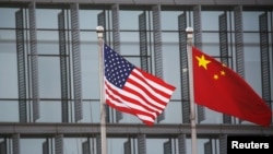 资料照片:美中国旗在一家美国公司驻北京的办公楼外飘扬。(2021年1月21日)