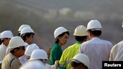 缅甸民主派领袖昂山素季在沙伦基镇与失去土地的村民会面之后观察铜矿。(2013年3月14日资料照)