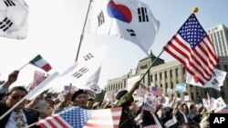 资料照:美韩同盟的支持者在一个集会上挥舞美国和韩国国旗。(2005年10月24日)