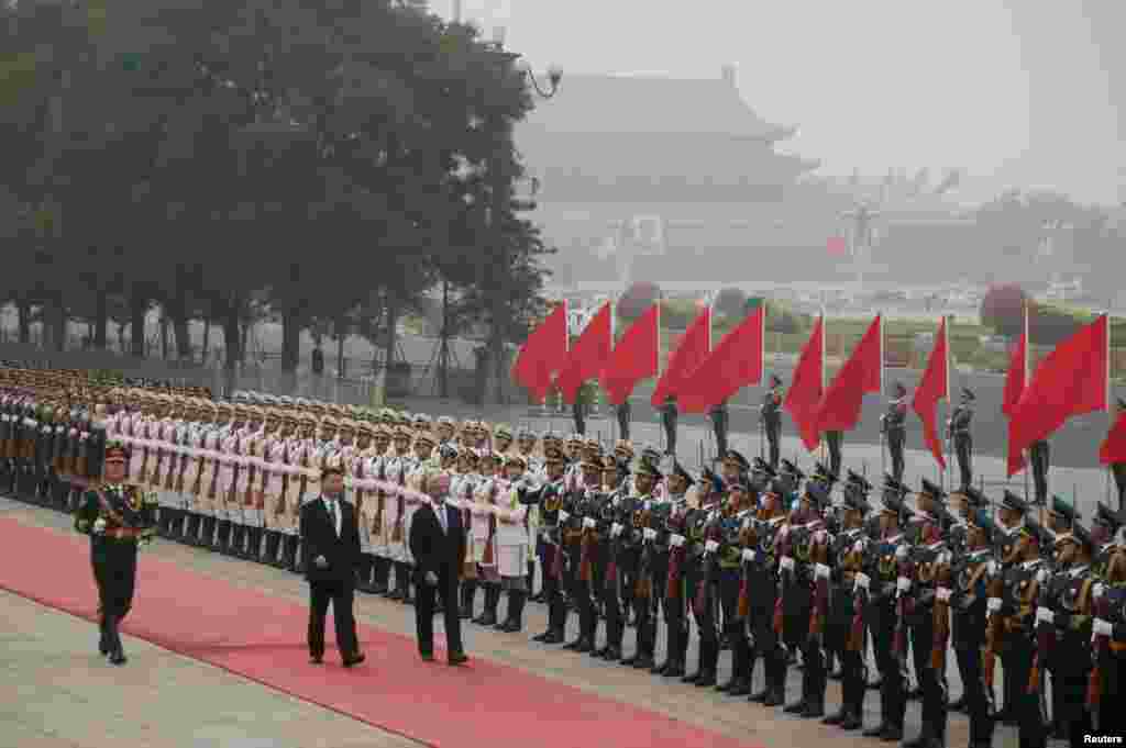 中国主席习近平和乌拉圭总统巴斯克斯在雾霾中的天安门广场上的欢迎仪式中检阅仪仗队(2016年10月18日)