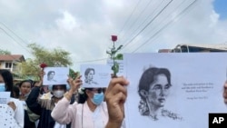 缅甸德林达依地区朗隆镇的示威者2024年6月19日手举印有昂山素季肖像和名言的标语,庆祝她的79岁生日。