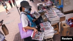 资料照:香港市民在街头报摊上购买苹果日报。(2020年8月11日)