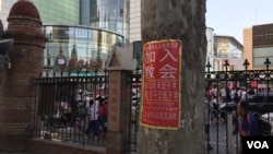 属于中国官方天主教爱国会系统的天津西开总堂在庭院贴出的招收新教徒的学习班通知,院外是喧嚣的商业区。(资料照)