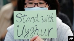 一名男子在香港支持维吾尔人人权的集会中打着支持维吾尔人的牌子 (2019年12月22日)