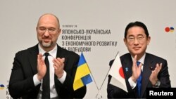 在东京举行的日本-乌克兰推动经济增长与重建会议期间,乌克兰总理什梅加尔和日本首相岸田文雄参加合作交流谅解备忘录的签署仪式。(2024年2月19日)