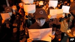 2022年11月27日,北京街头的抗议者们手举白纸。