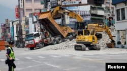 2024年4月4日,工作人员正在台湾花莲市一个街区应对大地震产生的房屋倾塌。
