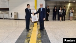 在香港西九龙高铁总站交接仪式上香港运输及房屋局局长陈帆(右)与中国深圳市人民政府的官员握手。(2018年9月3日)