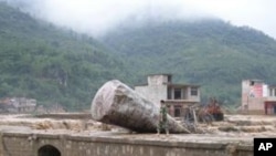 在同样遭受暴雨袭击的贵州省,一民警6月6日走过该省望谟县一座受灾桥梁
