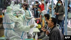 武汉一名医务人员正在对一位市民进行新冠状病毒检测。(2020年5月14日)