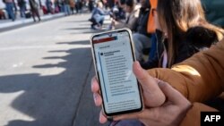 Шукач притулку показує оновлене повідомлення в додатку CBP One, у якому йдеться, що всі імміграційні співбесіди скасовано, Мексика, 20 січня 2025.