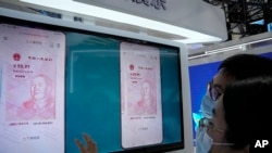在中国北京的一个贸易展览会上,参观者在看电子人民币(2021年9月5日)。