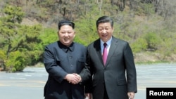 中国国家主席习近平(右)在大连与到访的朝鲜领导人金正恩握手。(2018年5月9日)