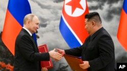 资料照片:俄罗斯总统普京和朝鲜领导人金正恩在朝鲜平壤举行的伙伴关系签署仪式上交换文件。(2024年6月19日)