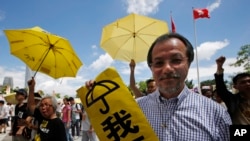香港民主派抗议者举着黄雨伞在香港立法会外集会。(2015年6月17日)