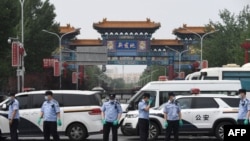 中国警察在被关闭的北京新发地农产品批发市场的入口处站岗。(2020年6月13日)