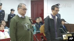 视频截图显示台湾人权工作者李明哲(左)在中国湖南岳阳中级法院出庭(2017年11月28日)。