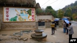 2016年10月22日,在中国陕西省梁家河,中国国家主席习近平青年时期生活过的窑洞外面,有一幅描绘青年习近平指引方向的壁画。