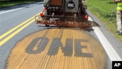 国际反贫困公益组织(ONE)成员格雷格将组织标识 - ONE - 喷洒在77号公路引起人们对贫困的认识