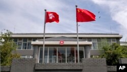 资料照:香港特区政府驻北京办事处前飘扬的中国国旗和香港旗帜。(2020年6月30日)