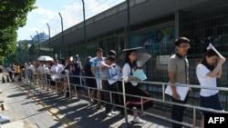 2018年7月26日,人们在北京的美国大使馆外面排队申请签证。