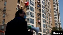 中国江西省九江市一个居民小区的居委会成员在宣传新冠防疫。(2020年2月4日)