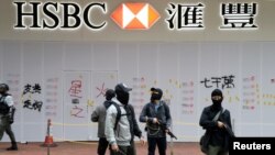 资料照:香港武装警察在一所被示威者破坏了的汇丰银行支行外站岗。(2020年1月1日)