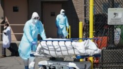 在纽约布鲁克林区一家医院外,工作人员把遗体送入一辆被当作临时停尸房的冷冻卡车。(2020年4月6日)