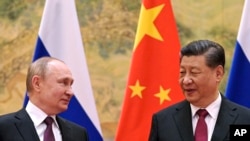 2022年2月4日,中国国家主席习近平(右)和俄罗斯总统弗拉基米尔·普京在中国北京举行的一次会晤中交谈。