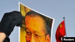 一位抗议者在中国驻奥斯陆大使馆门外举着刘晓波的照片。(资料照)