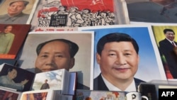 2018年2月26日,北京一个市场陈列的中国国家主席习近平像和前共产党领袖毛泽东像。毛泽东终身执政,掌权到死。