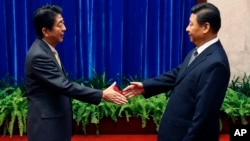 中国国家主席习近平和日本首相安倍晋三在人民大会堂握手。(2014年11月10日)
