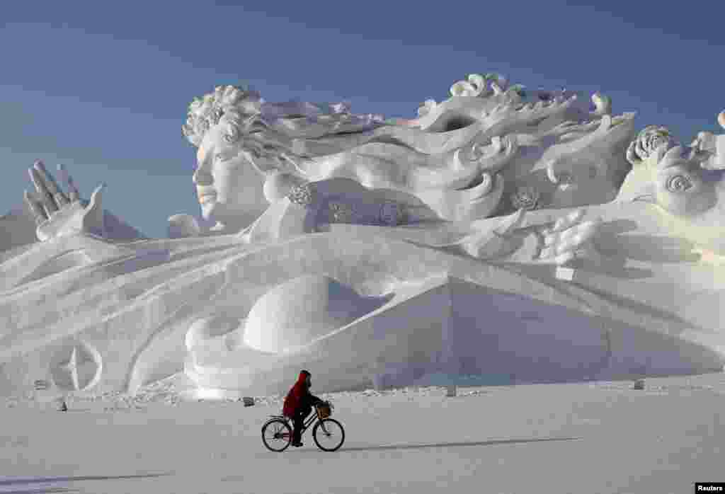 哈尔滨国际冰雪节的雪雕,有人骑车路过(2014年1月4日)