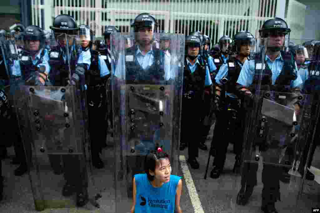 2019年6月12日,香港立法会外,一名抗议者坐在防暴警察面前。
