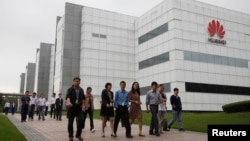 华为技术有限公司的员工走过广东省深圳市的公司办公楼。(资料照片)
