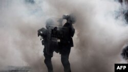 2019年6月12日,在香港政府总部外举行的反对有争议引渡法提案的集会上,警察被催泪瓦斯包围。