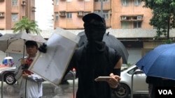 以全套Black Bloc打扮的一名汉华中学校友宣读公开信,不滿校方散播白色恐怖,”连一个口罩也容納不下”。(美国之音湯惠芸拍攝)