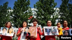 被拘押的中国维权律师家属在北京最高人民检察院前举牌抗议。(资料照片)