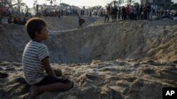 Palestinians look at the destruction after an Israeli airstrike on a crowded tent camp housing Palestinians displaced by the war in Muwasi, Gaza Strip, Sept. 10, 2024.