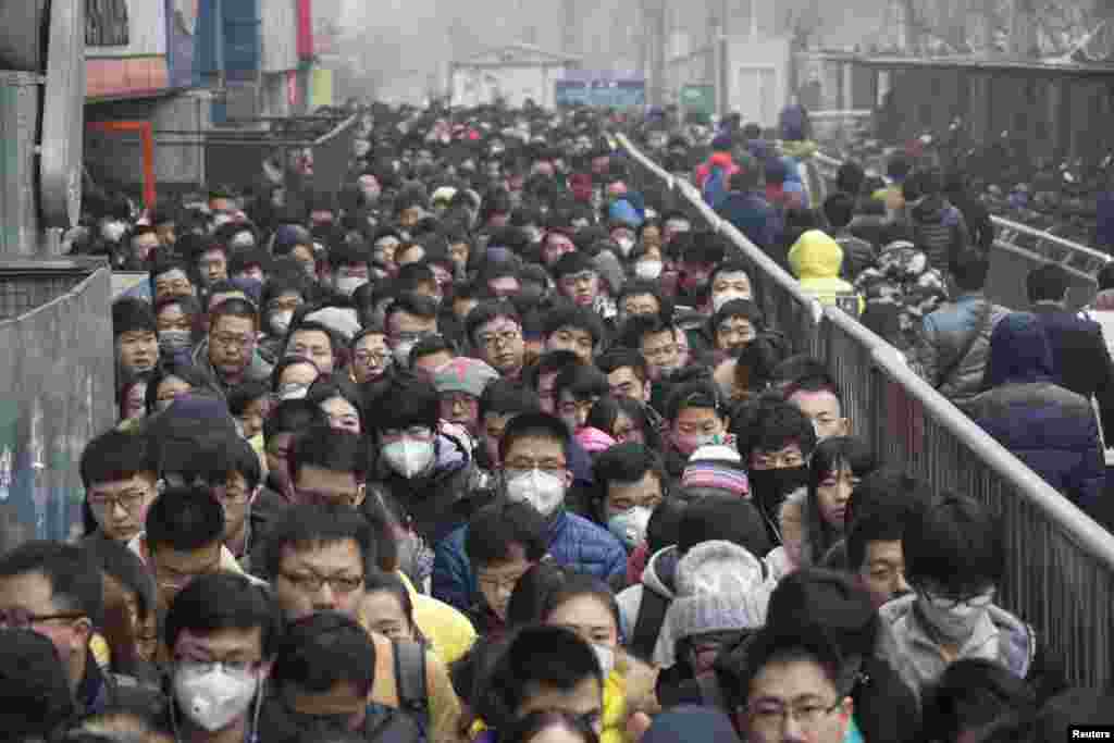 2015年12月8日,在北京首次发布空气污染红色警报后,乘客在地铁站排队