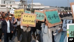乌坎村民12月15日举着标语牌,高呼口号,要求中央政府介入