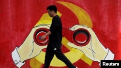 一名男子从上海街头中共党徽前走过。(2019年9月25日)