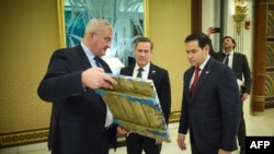 На цій фотографії від прес-служби Президента України (via AFP) зображено міністра закордонних справ України Андрія Сибігу, який показує ікону держсекретарю США Марко Рубіо та раднику США з національної безпеки Майку Валцу у Джидді, Саудівська Аравія, 11 березня 2025 року.