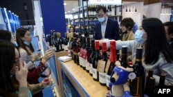 中国消费者在上海举行的第三届国际进口商品展览会上品尝澳大利亚的葡萄酒(2020年11月5日)